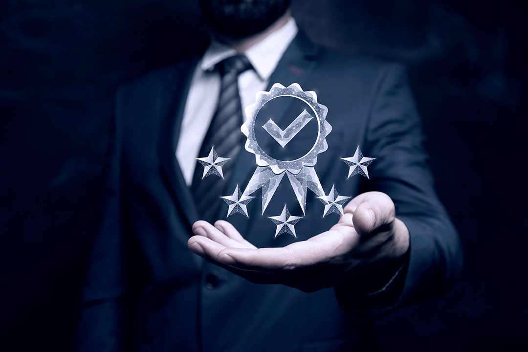 The symbol of the guarantor of quality and five stars from the network. Man holding in his hand